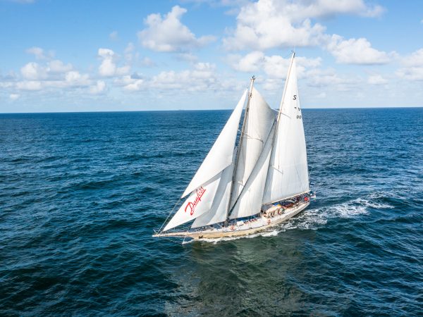 Suomen purjelaivasäätiö, kuunari Helena, atlantti, valtameri, dronekuva, valokuvaaja Jarno Artika, KUUNARI HELENA PURJEHDUS JUTTU 2 SUNNUNTAISUOMALAINEN Kuunari Helenan purjeet keulasta alkaen: flying jib, jib, fore staysail, sitten oleva purje fisherman staysail, main staysail ja isopurje eli main sail. Purjepinta-ala riittää kuljettamaan 110 000 kiloista alusta 8 solmun vauhtia kevyessä takamyötaisessä tuulessa.